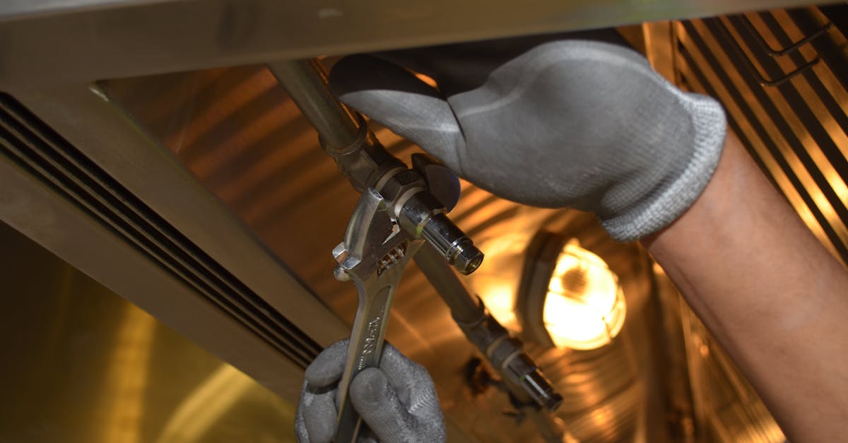 a worker fixing pipes with tools in an industrial indoor environment